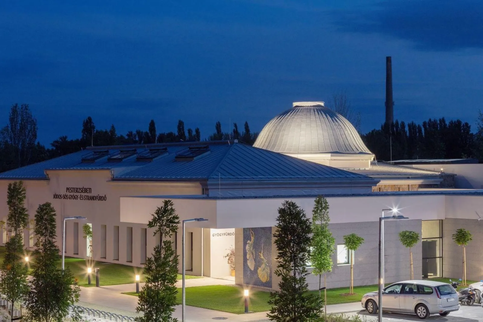 Pesterzsébet spa building at night with its silver dome and lit entrance