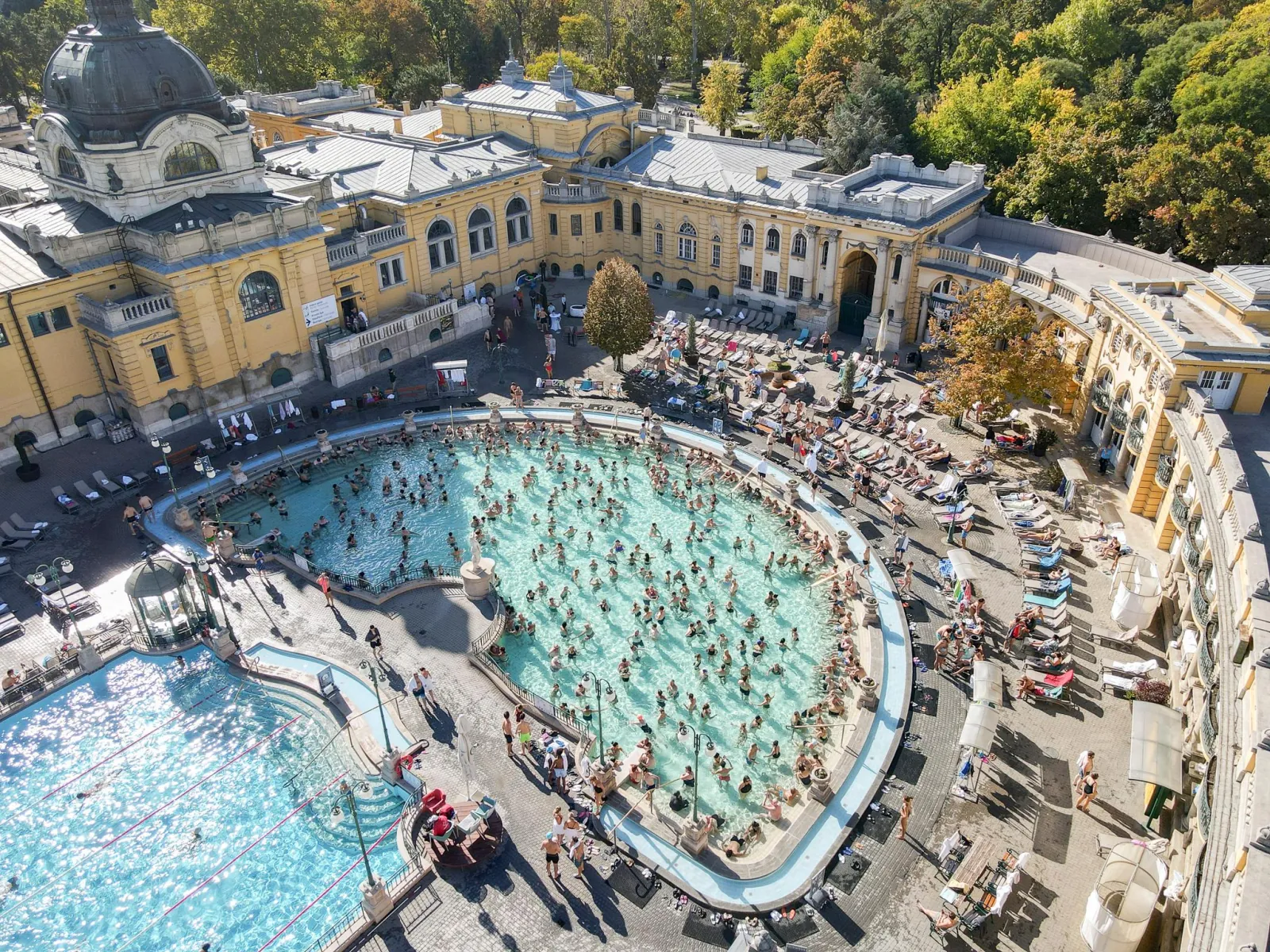Aerial view of Széchenyi's busy outdoor pools and courtyard in autumn
