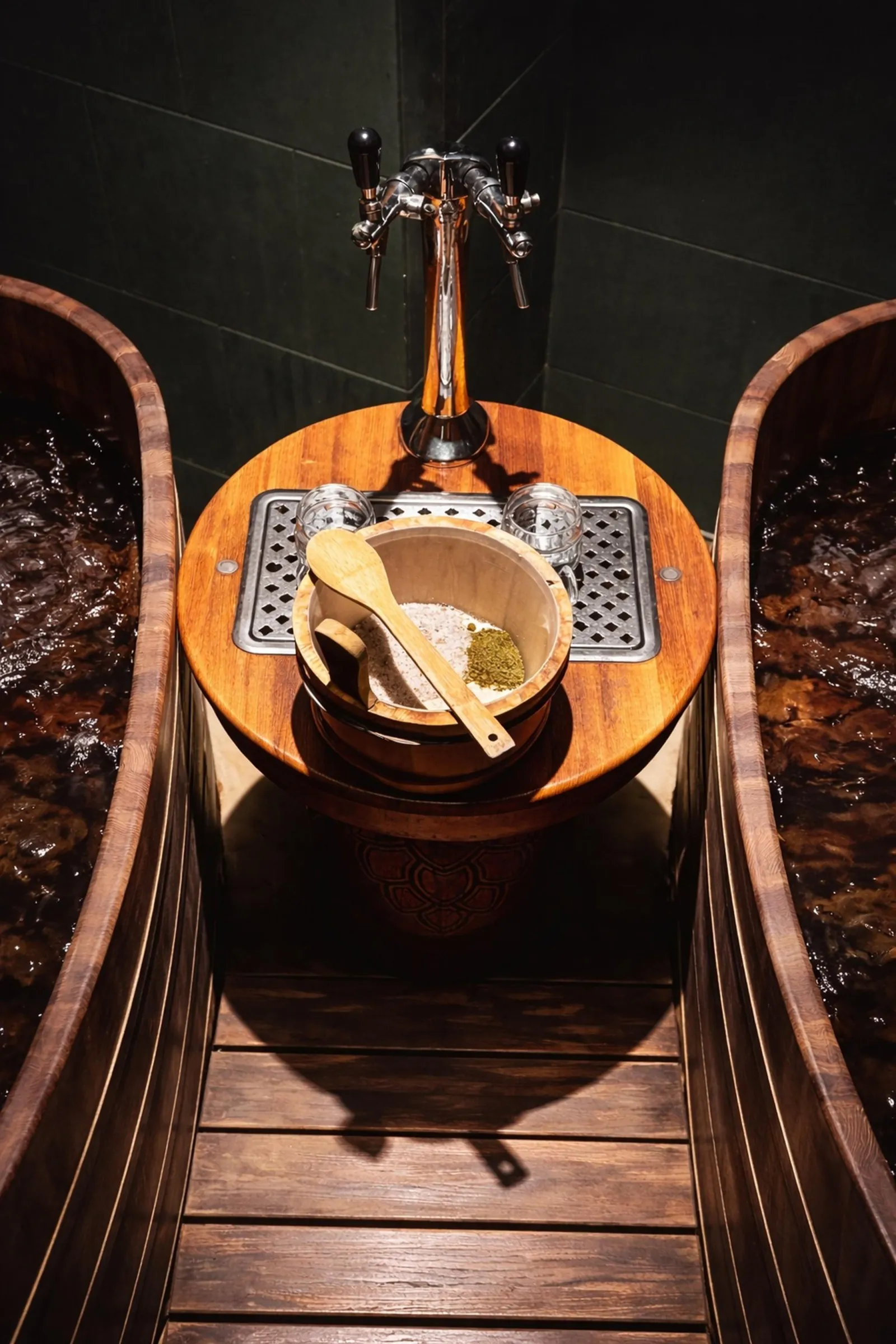 Overhead view of two wooden tubs with a beer tap and a bucket of hops and brewer's salt