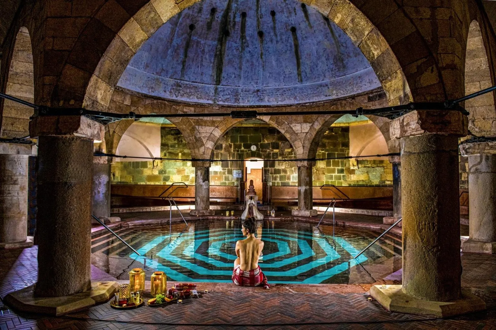 Octagonal Turkish bath pool at Rudas under a stone dome on thick columns, a bather at the edge