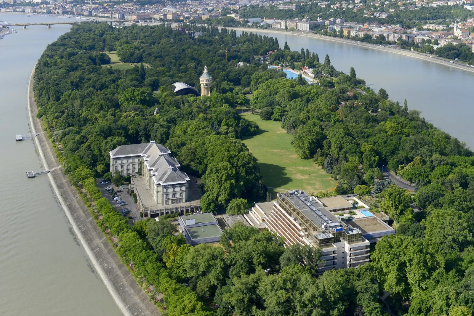 Aerial view of Margaret Island with the Ensana hotel buildings among trees beside the Danube