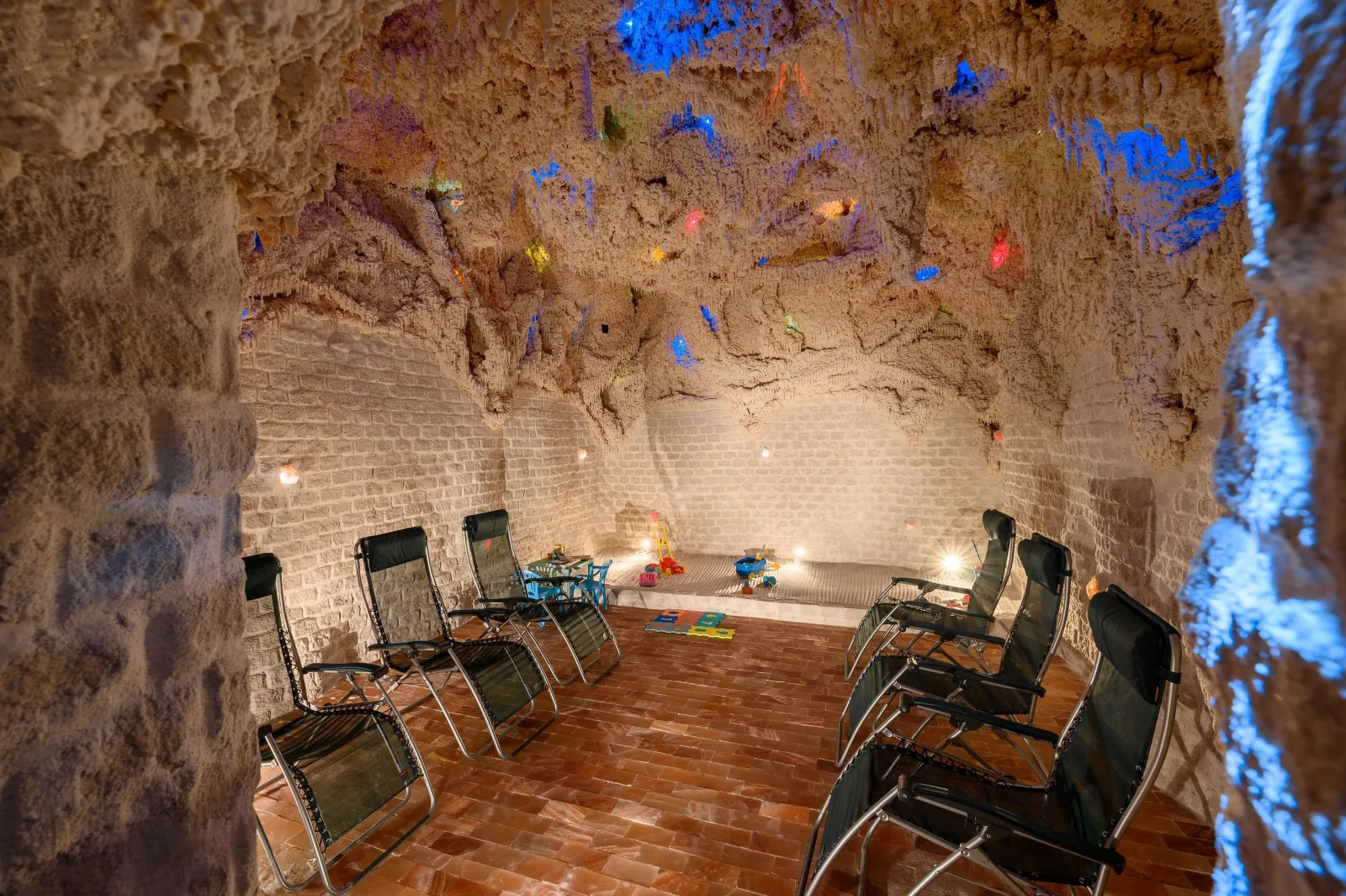 Salt cave with reclining loungers, rough stone walls and soft blue lights