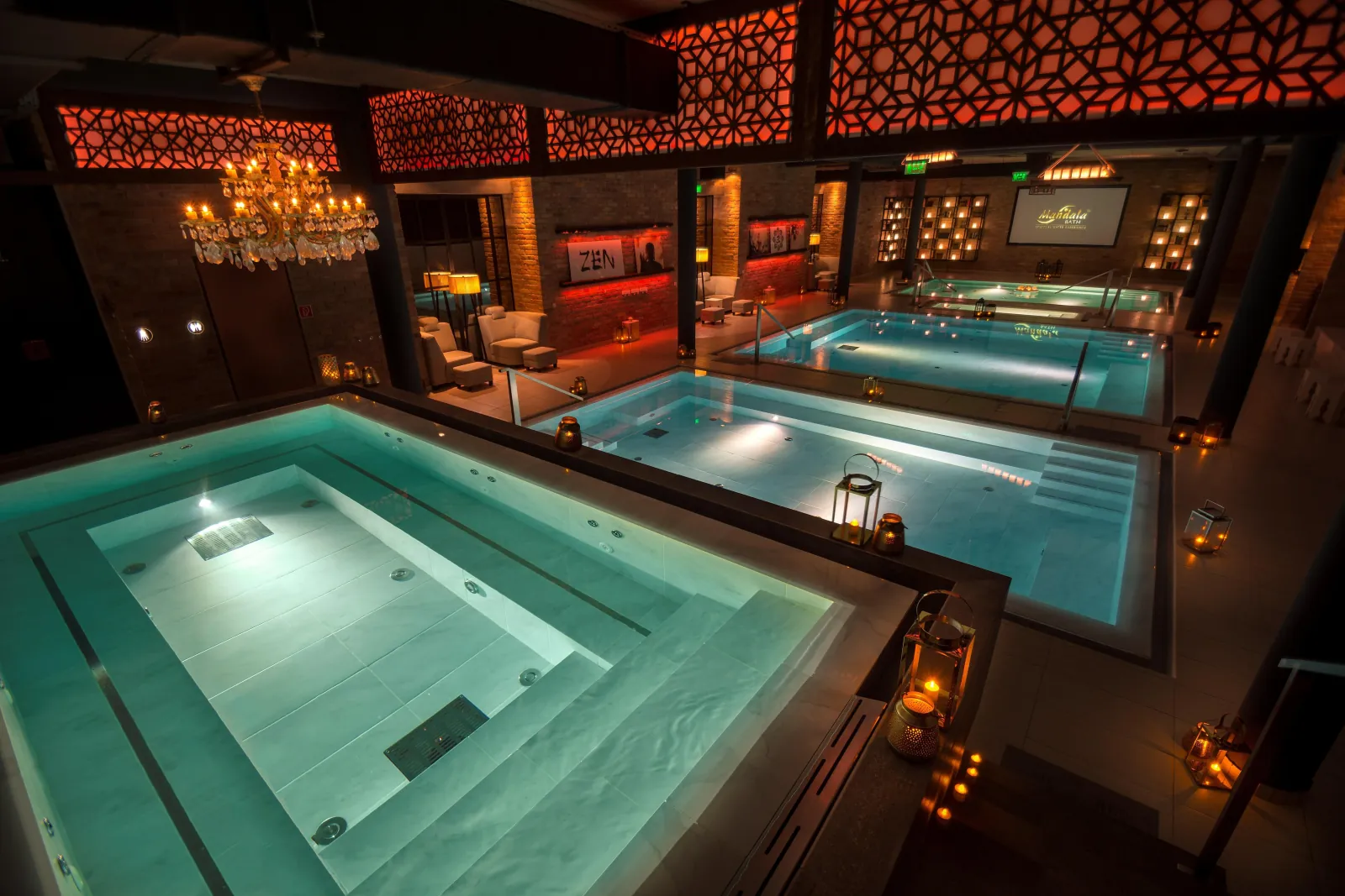 Mandala's pool hall from above, with lit pools, a chandelier and red lattice ceiling panels